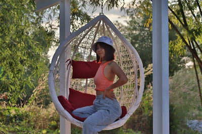 Portrait of smiling woman sitting by tree