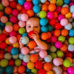 High angle portrait of baby boy playing with colorful balls