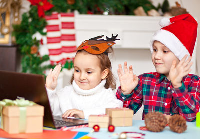 Portrait of cute girl playing with christmas tree at home