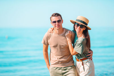 Young man wearing sunglasses against sea against sky