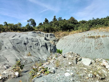 Scenic view of rocky shore against sky