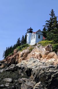 Lighthouse on cliff against clear sky