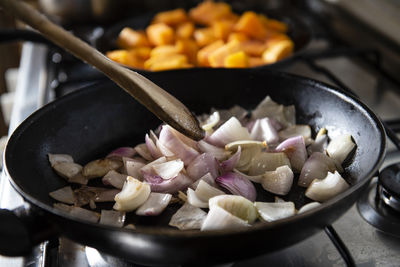 Woman cooking a vegetable soup with pumpkin, potato and onion. s