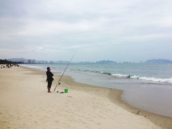 Man standing on beach against sky