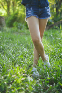 Low section of woman walking on field