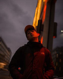 Low angle view of man looking at camera against sky