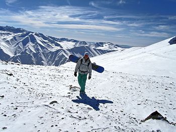 Full length of person on snowcapped mountain against sky