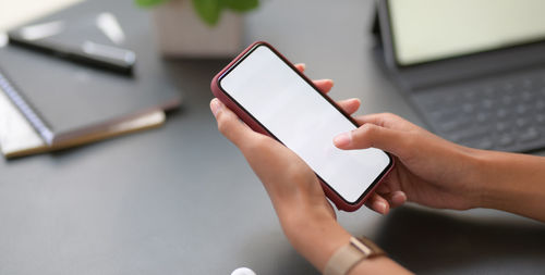 Cropped hands of woman using mobile phone