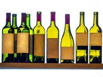 Close-up of empty glass bottles against white background
