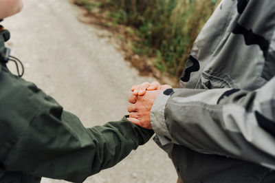 Man and boy hold hands tightly in military tourist clothing. friendly relations between generations