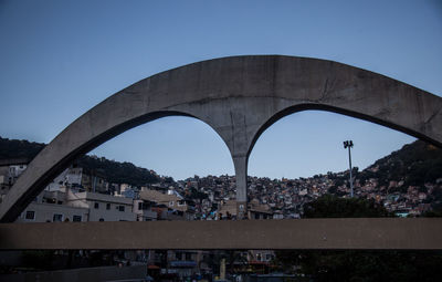 Arch bridge in city against clear sky