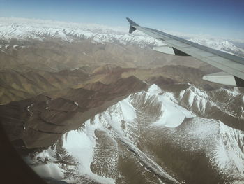 Aerial view of snow covered mountains against sky