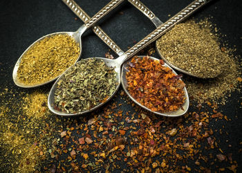 Close-up of seasoning in spoons on table