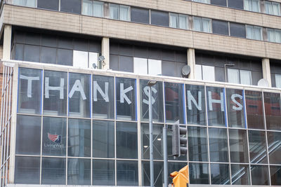 Low angle view of text on glass building