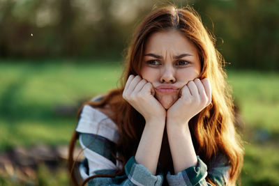 Portrait of young woman sitting on field