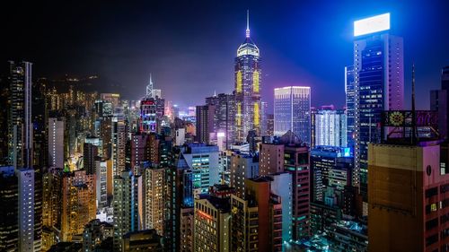 Illuminated cityscape against sky at night