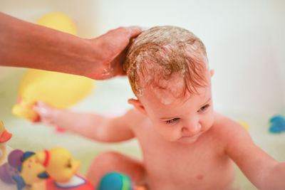 Cropped hand bathing baby girl