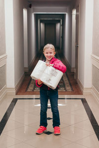 Full length portrait of girl standing at home