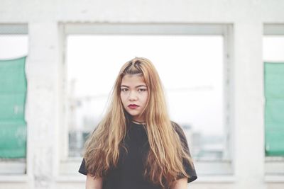 Portrait of young woman with long brown hair at construction site