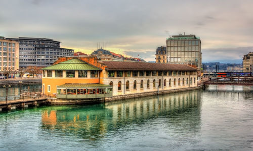 Buildings in city against cloudy sky