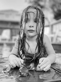 Portrait of young girl sitting in swimming pool