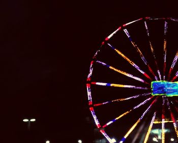 Low angle view of illuminated ferris wheel at night