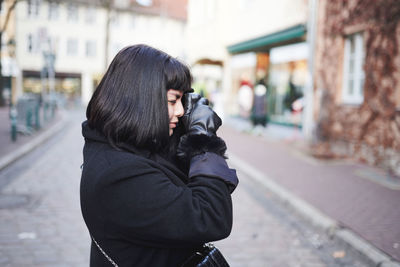 Beautiful woman with black hair making picture outdoors