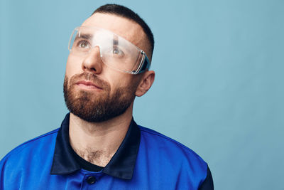 Portrait of young man against blue background