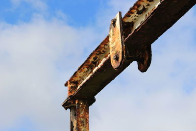 Low angle view of rusty metal against sky