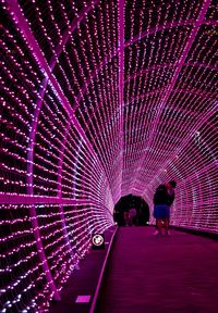 People in illuminated tunnel