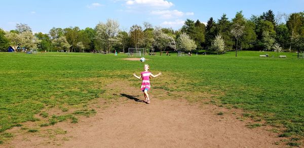 Rear view of woman on field against sky