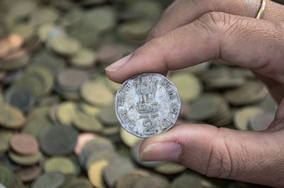 Cropped hand of person holding coin