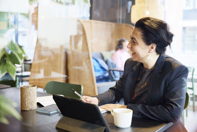 Smiling businesswoman sitting in cafe