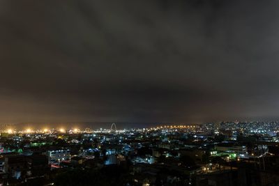 Illuminated cityscape against sky at night