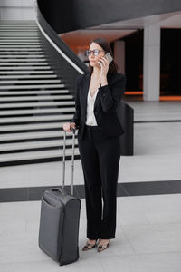 Full length of young woman using mobile phone