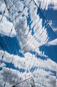 Glass building with reflection of cloudy sky