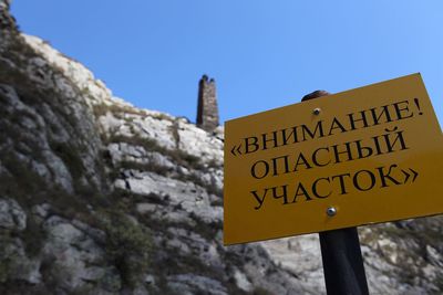 Low angle view of information sign against clear sky