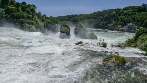 Scenic view of waterfall against sky