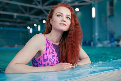 Beautiful redhead woman in swimming pool