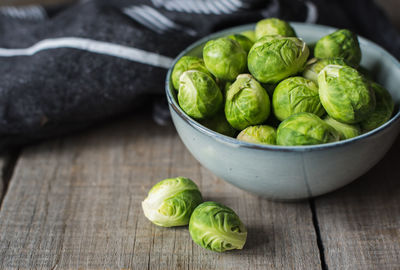 Bowl of brussels sprouts and napkin on a rustic wooden table.