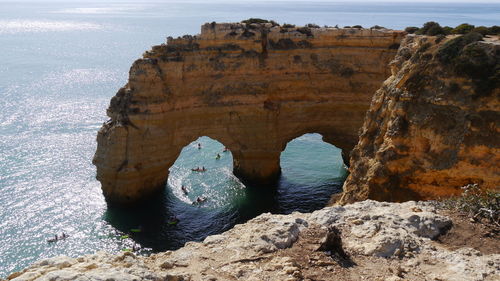 Rock formation on sea shore against sky