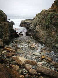 Rocks on beach against sky