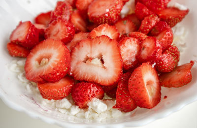 A close-up of a plate of cottage cheese with strawberries, the concept of a healthy summer 