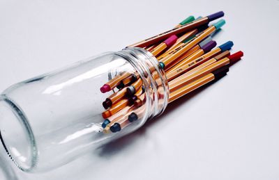 Close-up of colored pencils over white background