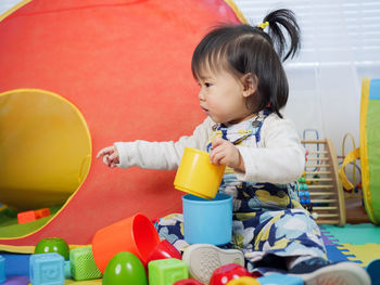 Cute baby girl playing with toys at home