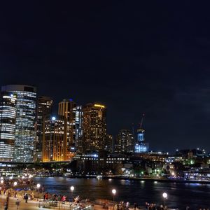 Illuminated buildings in city against sky at night