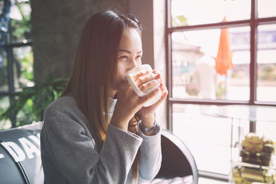 Portrait of young woman drinking coffee cup