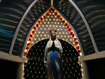 Low angle view of man standing against illuminated building