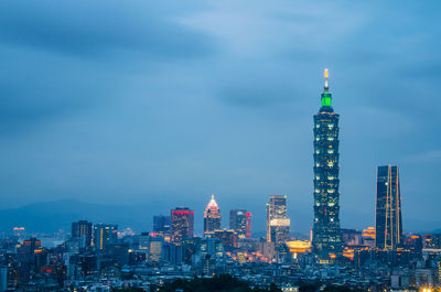 Illuminated buildings in city against sky