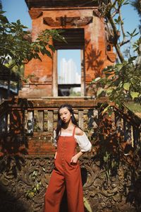Portrait of woman standing by tree